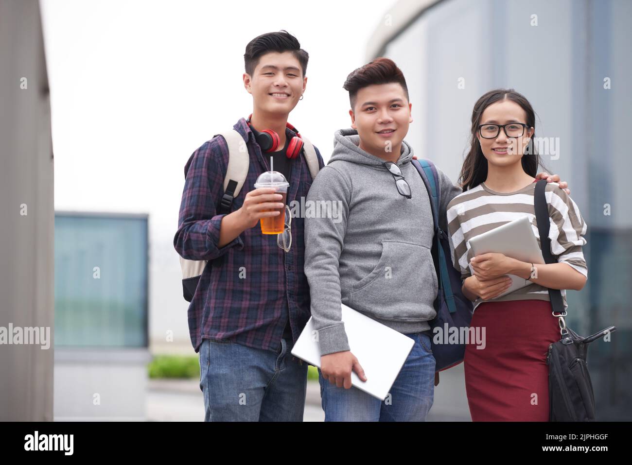 Group portrait of cheerful Asian students looking at camera with wide ...
