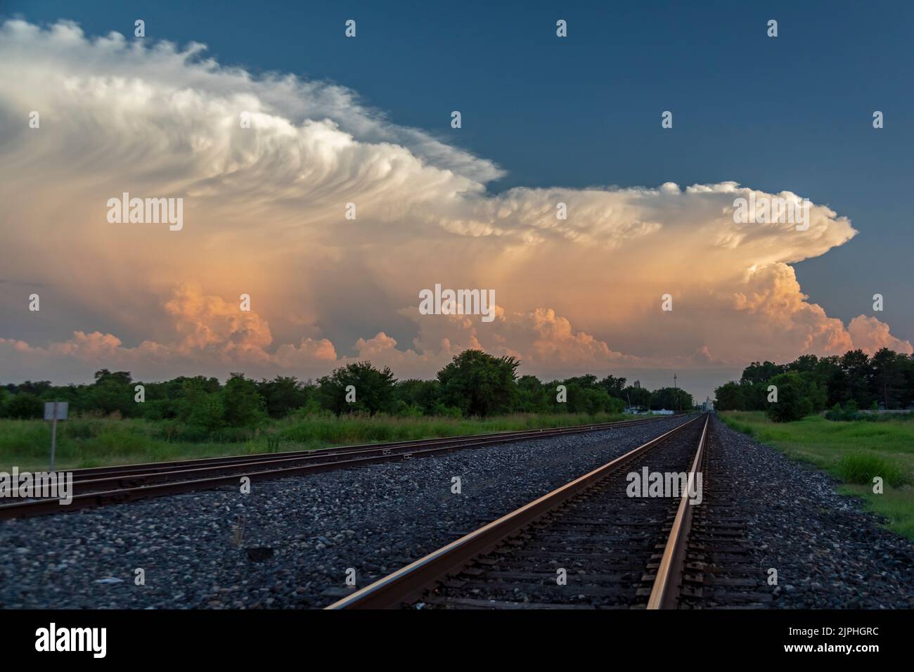 Hutchinson, Kansas - Storm clouds over railroad tracks at sunset in central Kansas. Stock Photo
