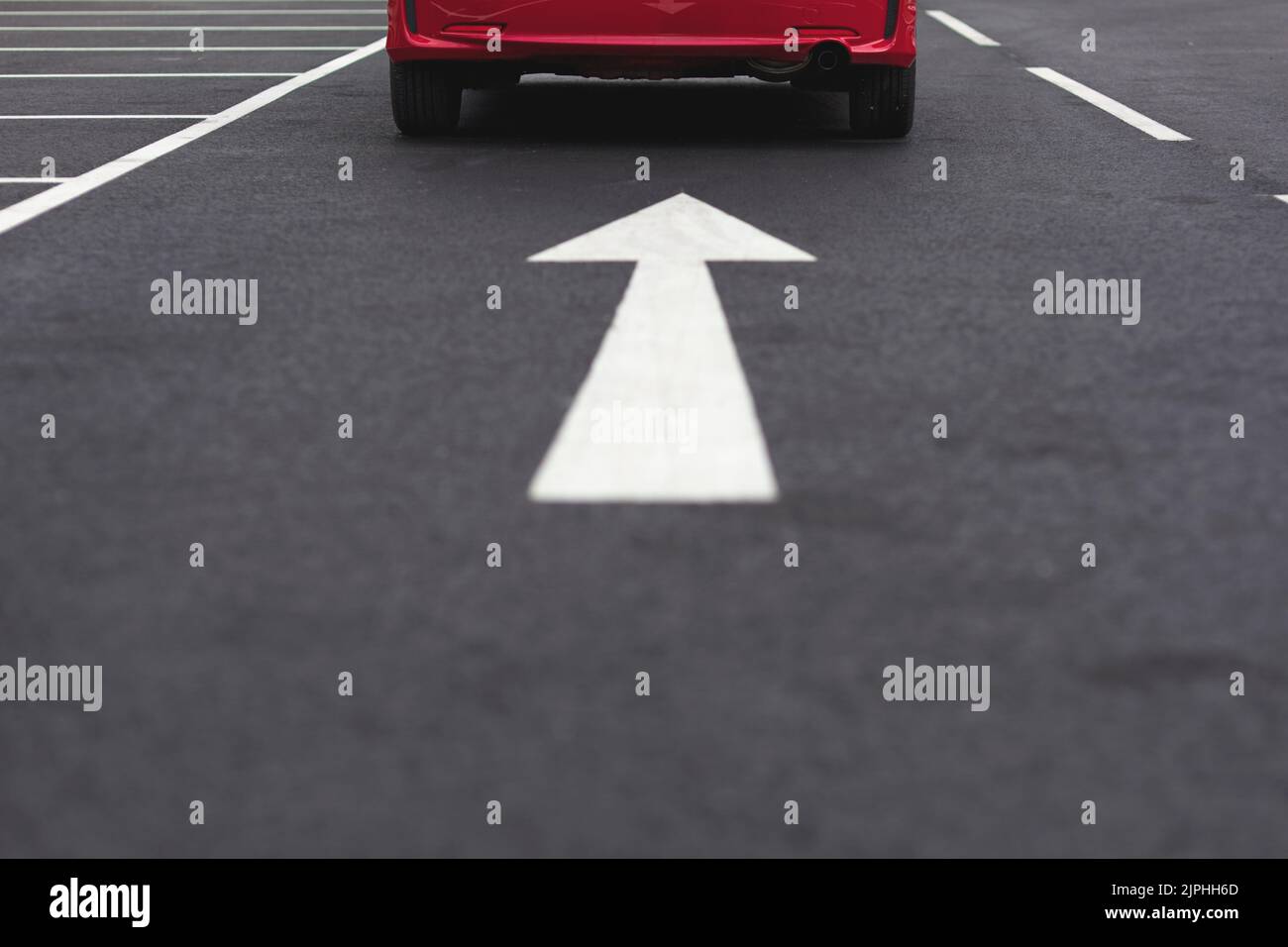 Red car following arrow on ground Stock Photo