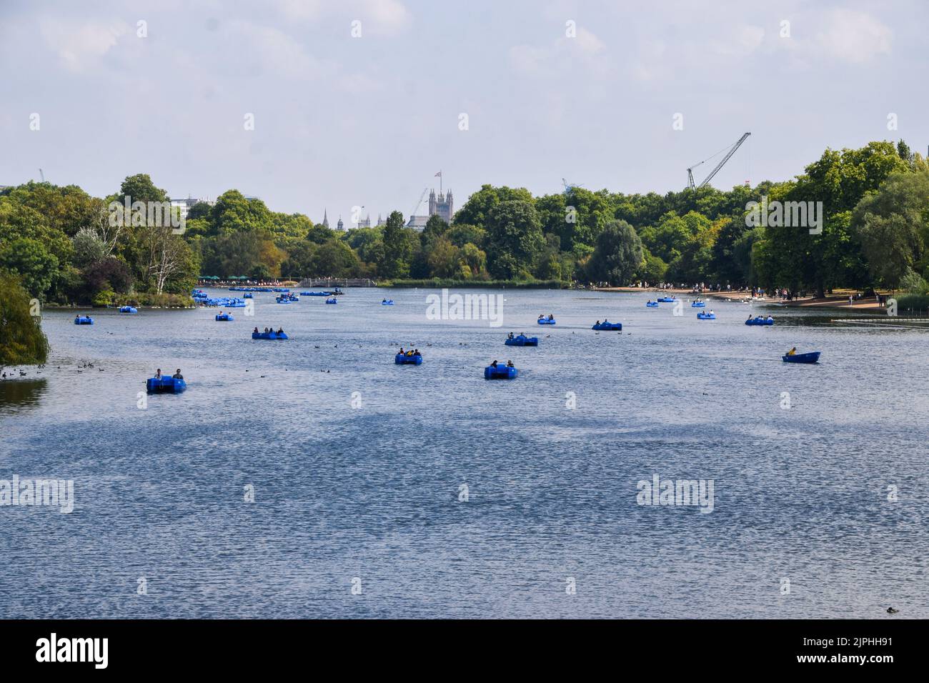 London, UK. 18th August 2022. People ride in pedal boats on The Serpentine in Hyde Park as high