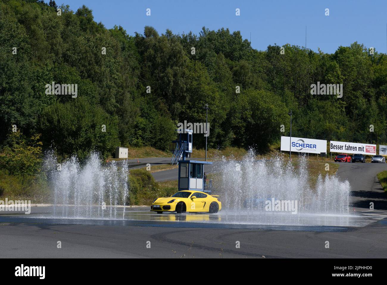 Porsche Cayman GT4 bei Fahrsicherheitstraining, links rechts Wasserfontäne, Fahrsicherheitszentrum, Nürburgring, Rheinland-Pfalz, Deutschland, EU Stock Photo