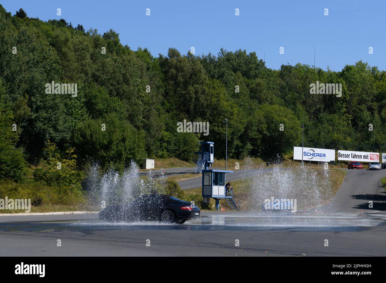 Porsche 911 bei Fahrsicherheitstraining, schleudert in Wasserfontäne, Fahrsicherheitszentrum, Nürburgring, Rheinland-Pfalz, Deutschland, Europa Stock Photo