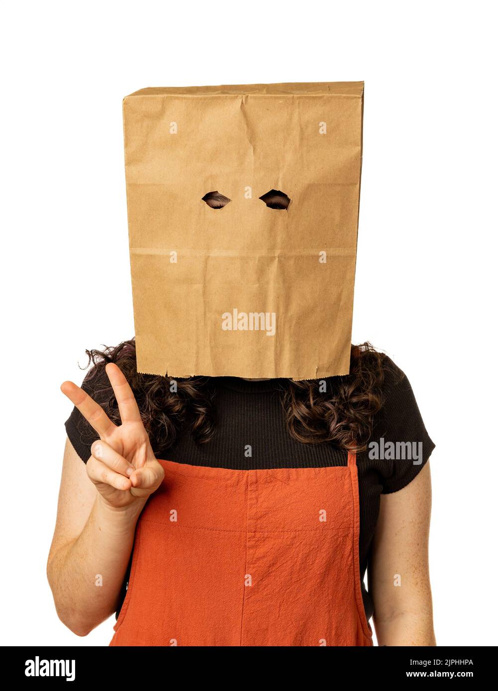 Woman wearing paper bag over her head and giving the peace sign Stock Photo