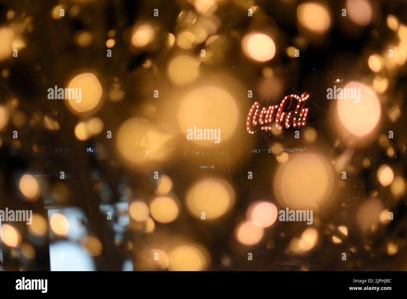 The Coca-Cola logo through intense bokeh lights. Stock Photo