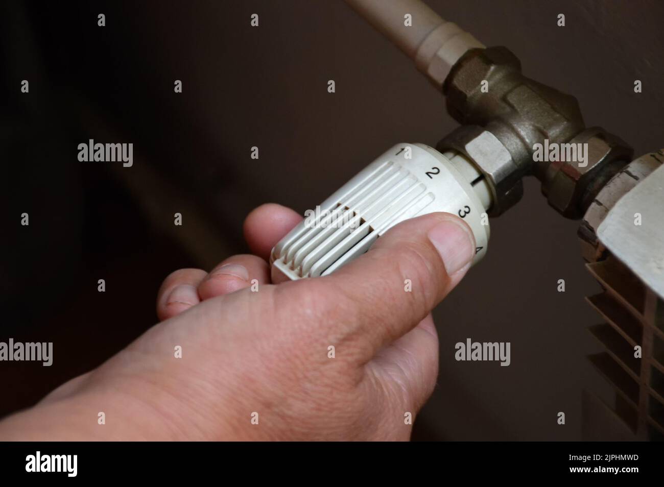 Controlling central heating temperature by adjusting thermostatic radiator valve Stock Photo