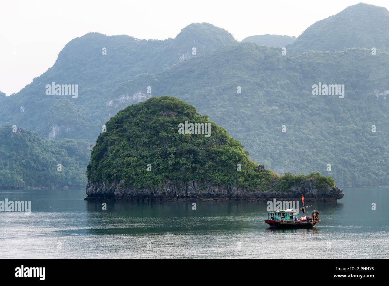 Fishing boat against whale shaped island Stock Photo