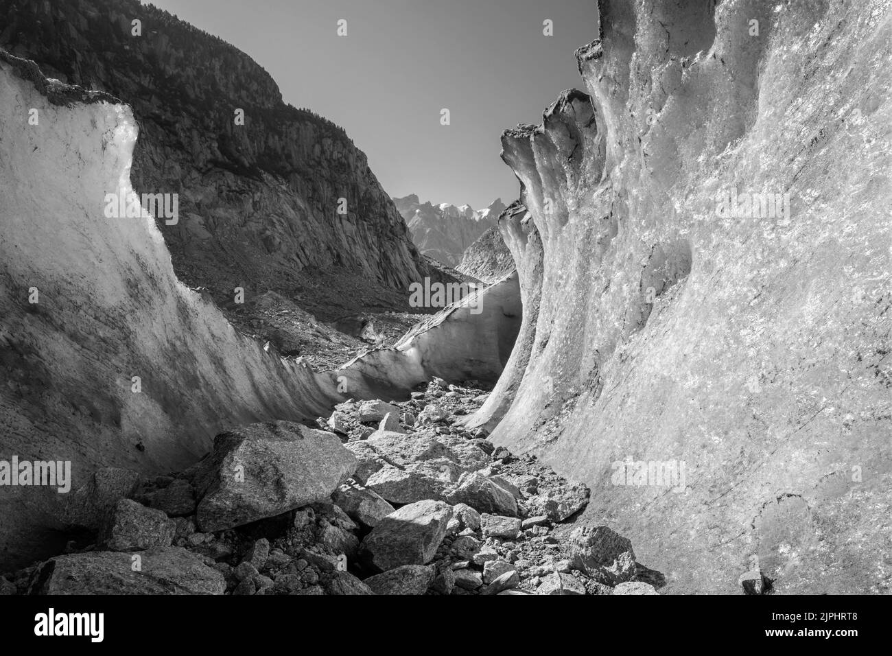 The natural glacial cave the glacier Mer de Glace with the Aiguilles towers in the background. Stock Photo