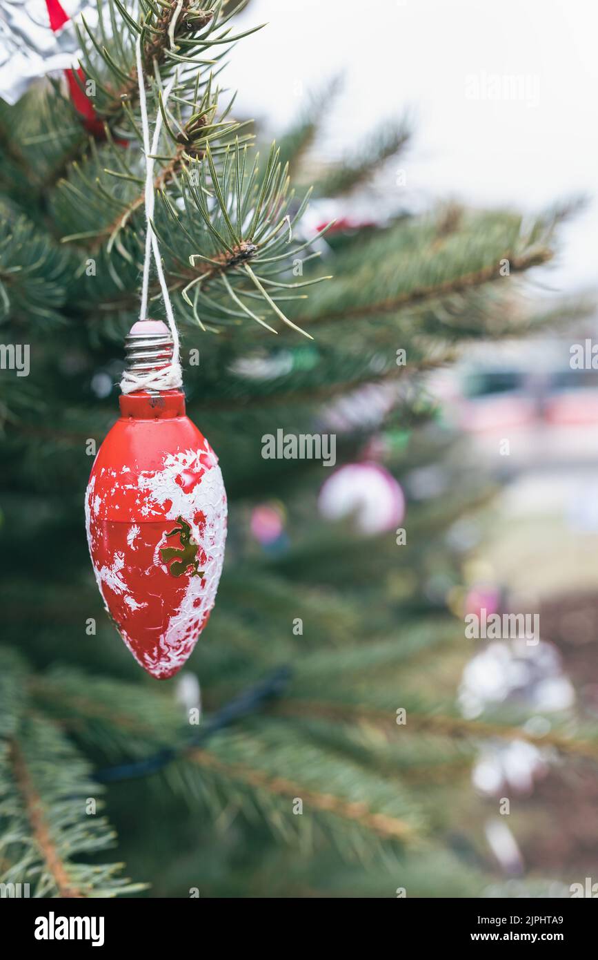 Painted white and red old light bulb decoration on Christmas tree. Diy