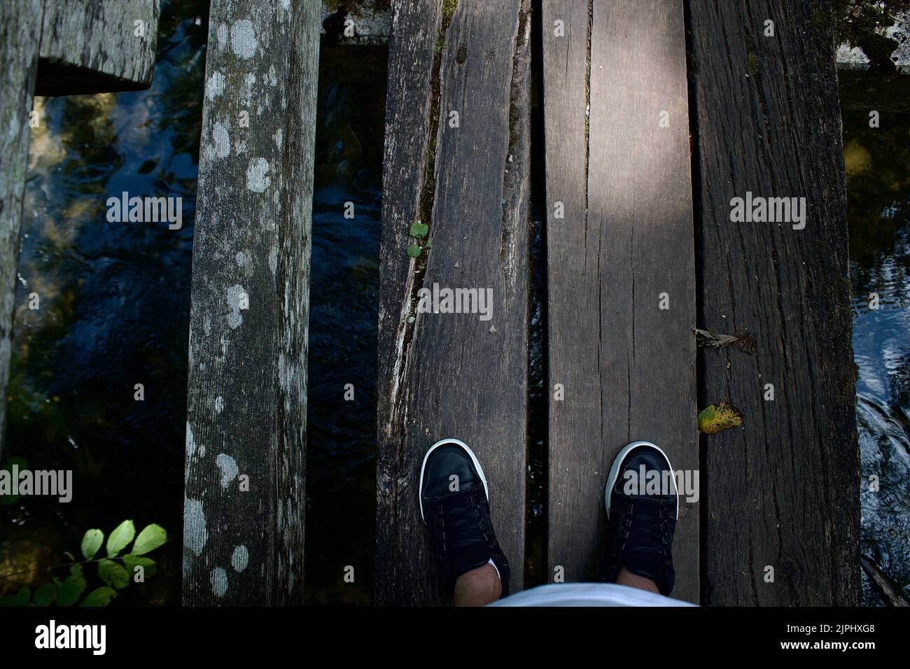 Ein paar Füße auf einer holzbrücke mitten im Wald in Sigmaringen Stock Photo