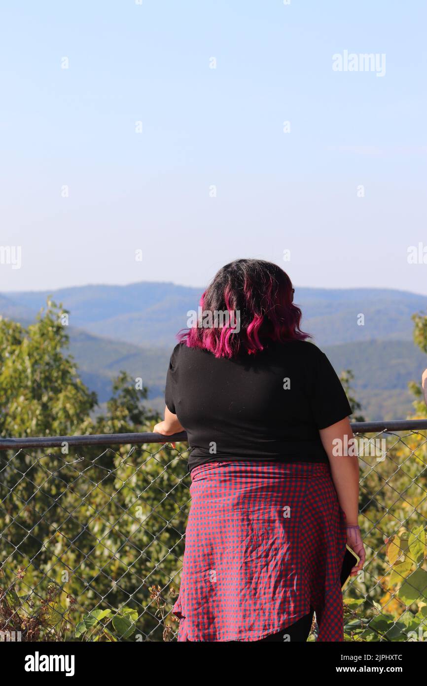 A woman standing with her back to the camera as she admires the view ...