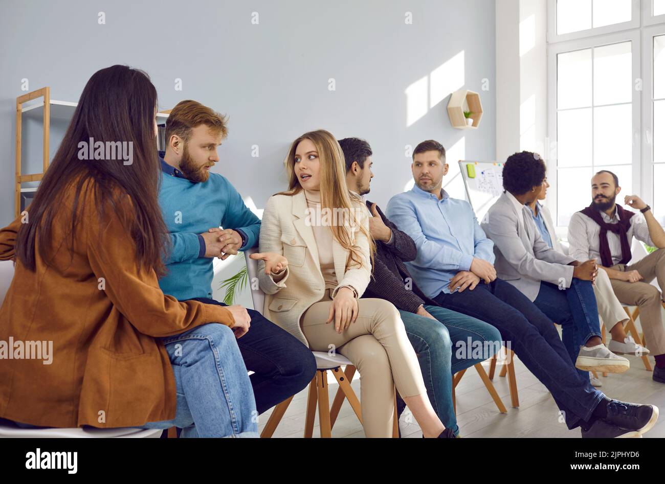 Team of entrepreneurs or corporate managers sitting in office and discussing something Stock Photo