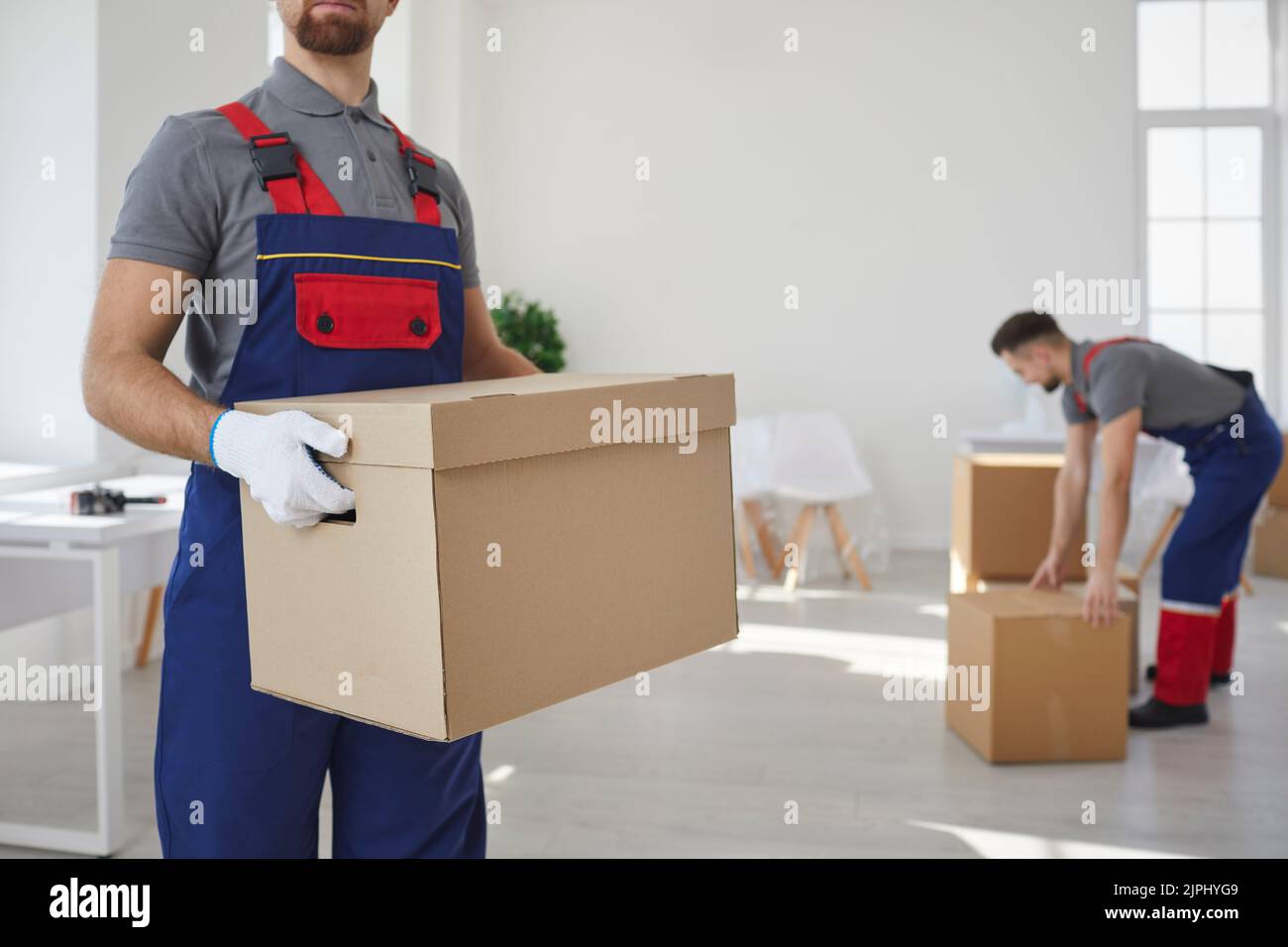 Male movers team carry boxes at relocation Stock Photo