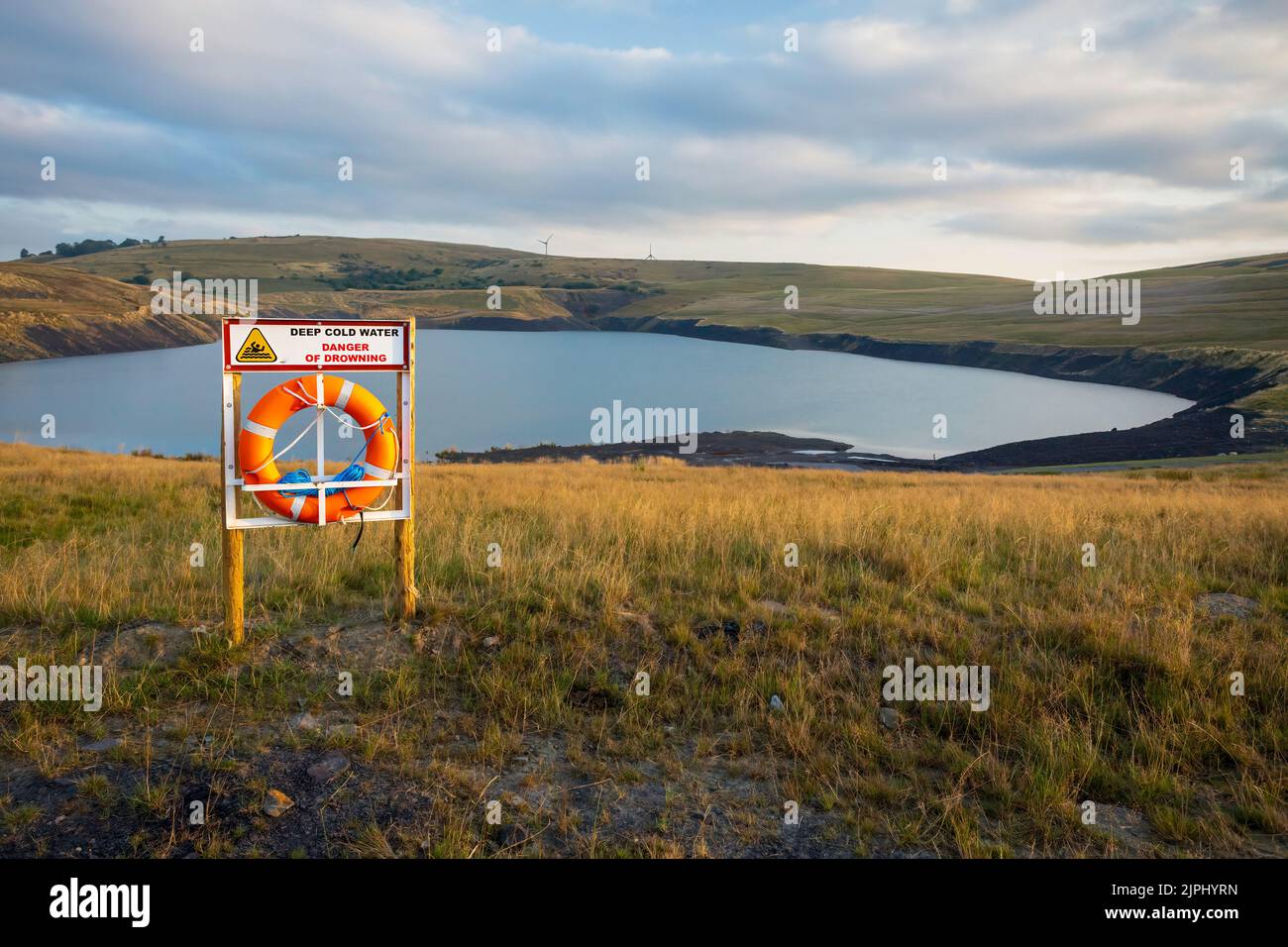A lifesaver on a lake with a danger of drowning sign in South Wales UK Stock Photo