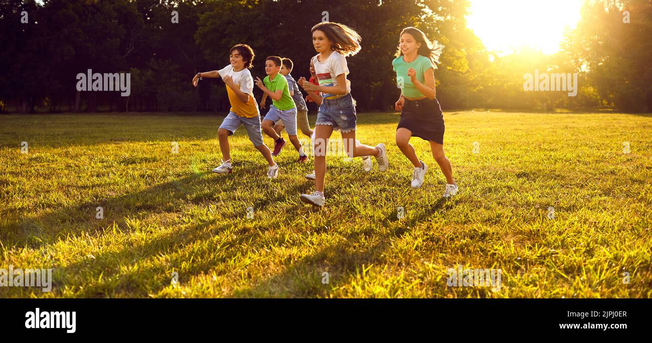 Group of happy little children enjoying summer, running in the park and having fun Stock Photo