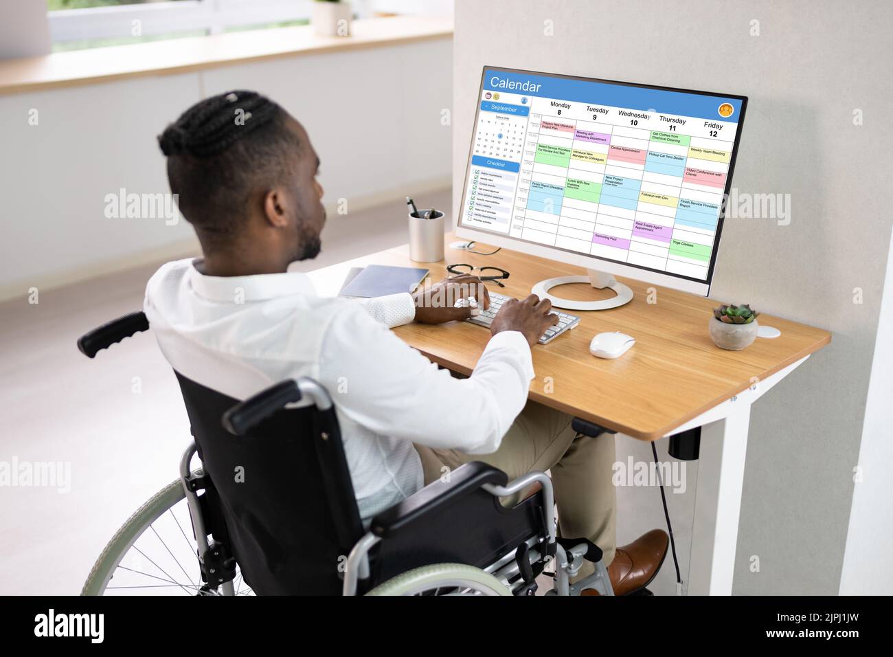 African american looking at agenda using calendar on computer stock