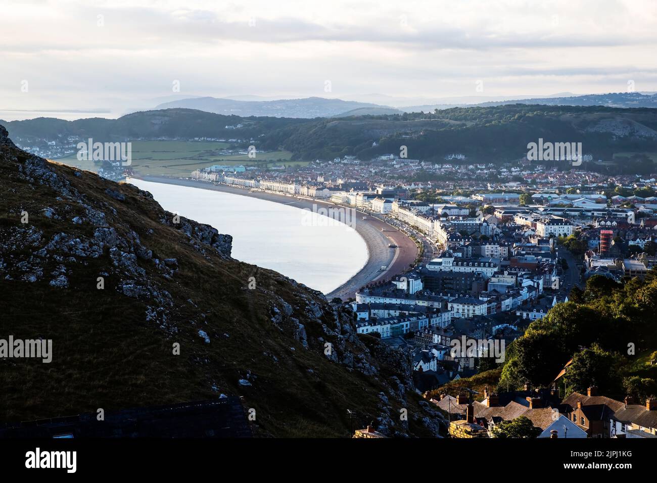 Llandudno resort North Shore, Hotels and Promenade lit by the first rays of sunrise over the Irish Sea in Summer as dawn breaks Stock Photo