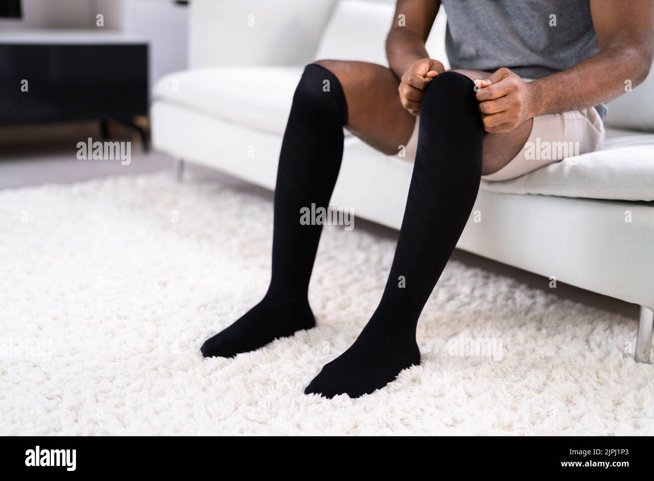 Man Putting On Medical Compression Stockings On Legs Stock Photo Alamy