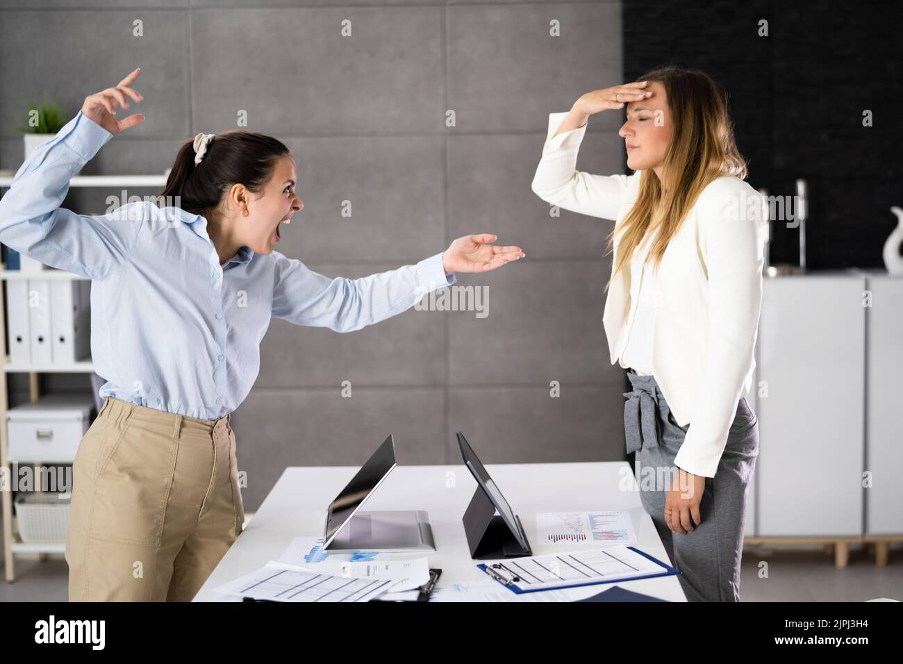 Office Quarrel. Worker Women Fighting Each Other Stock Photo