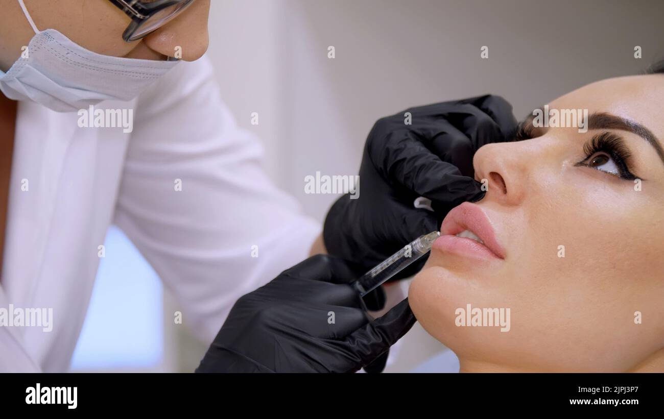 medical office, doctor in black sterile gloves, injecting hyaluronic