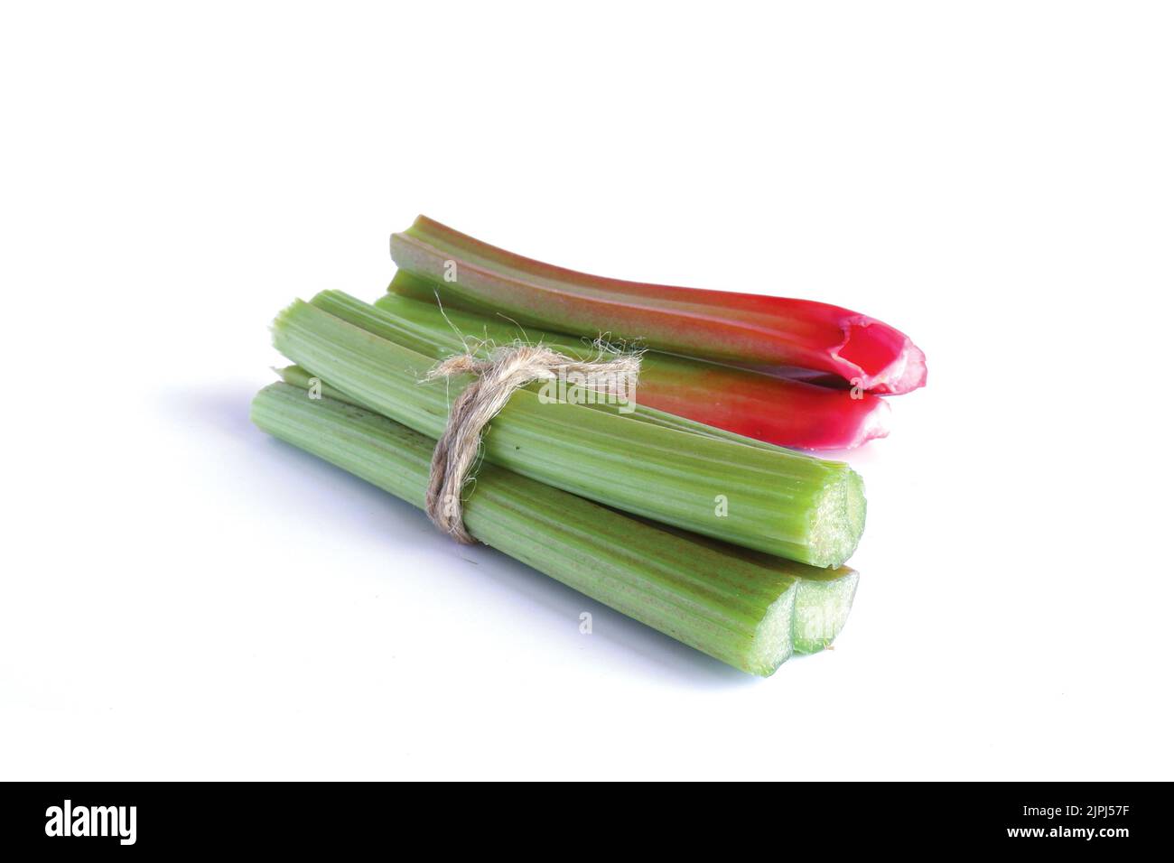 Red and green rhubarb stalks, tied with twine on a white background. Fresh useful plant from the garden.  Stock Photo