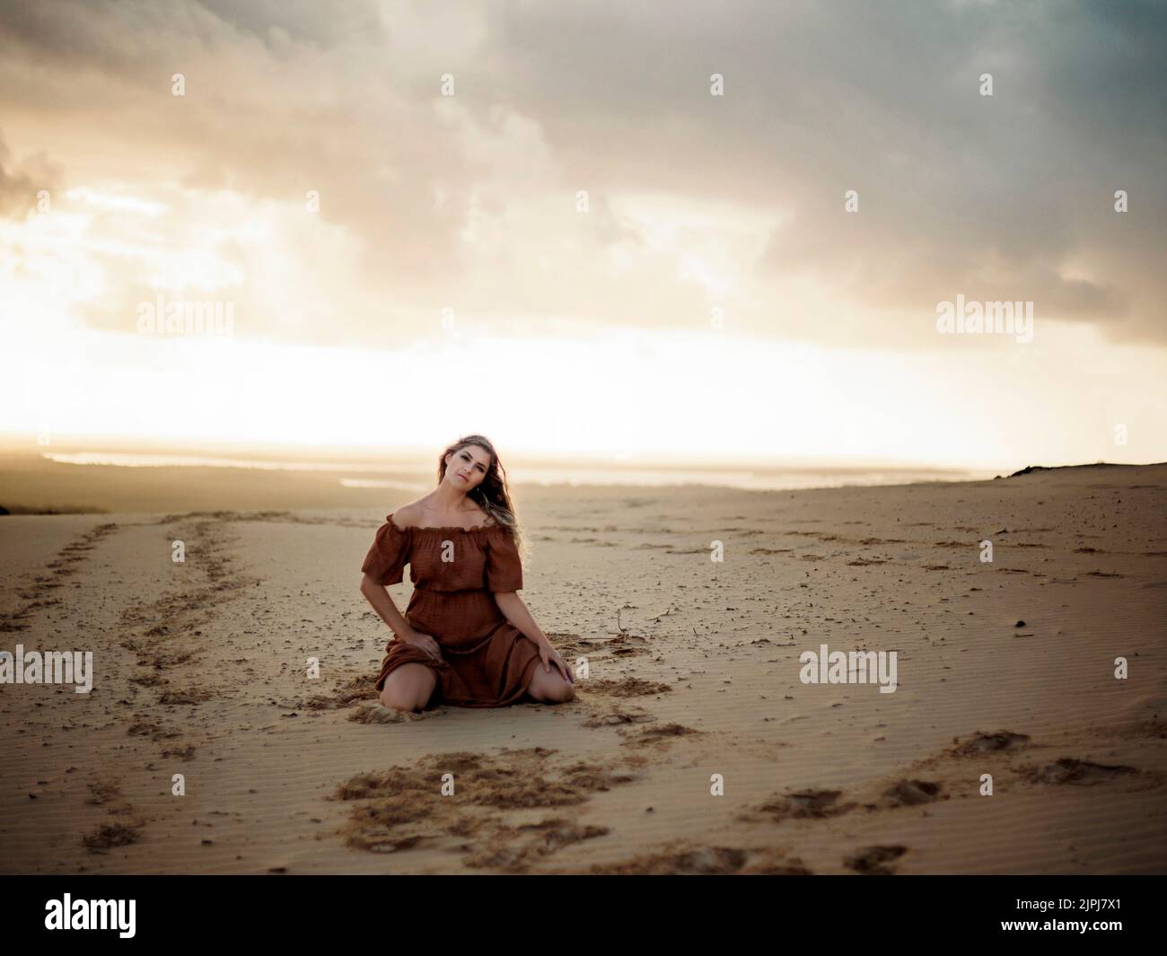 Woman kneeling on beach sunset hi-res stock photography and images - Alamy