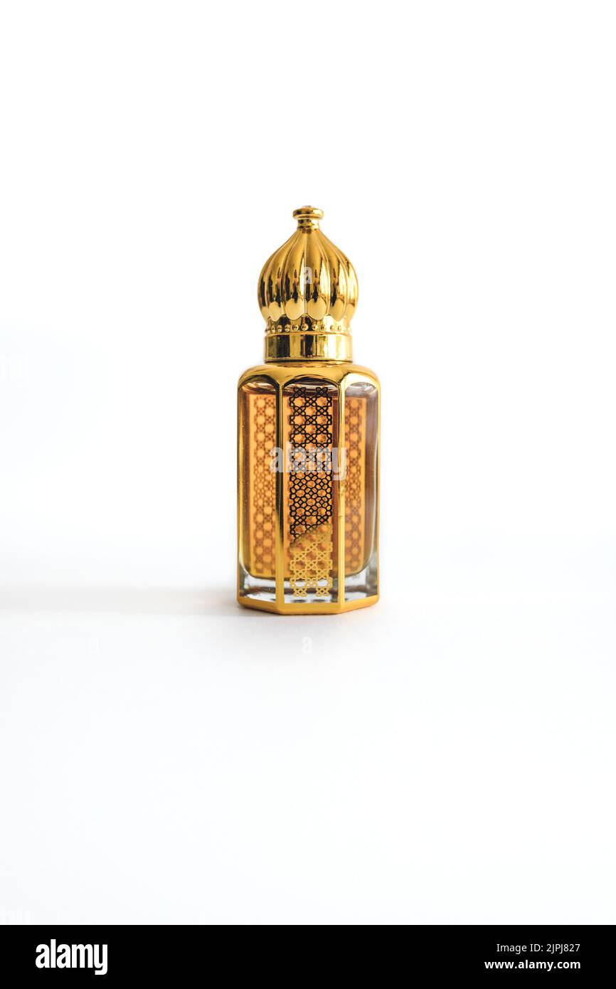 Arabian oud perfume in mini gold bottle. Isolated on white background