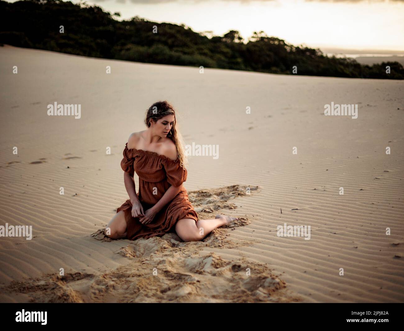 Woman kneeling sand beach sunset beach hi-res stock photography and ...