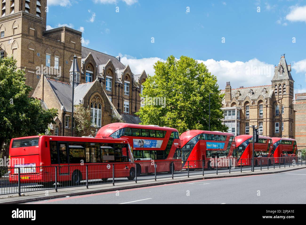 Buses waiting at the bus stand on Archway Road, the presently uninhabited 'Holborn Infirmary' building behind, Islington, London, UK Stock Photo