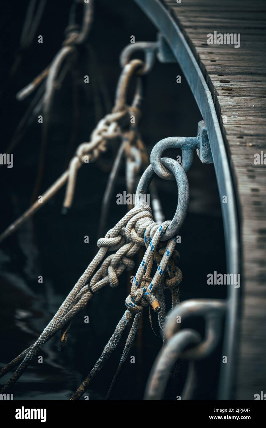 A vertical shot of ropes tied to metallic circles Stock Photo - Alamy