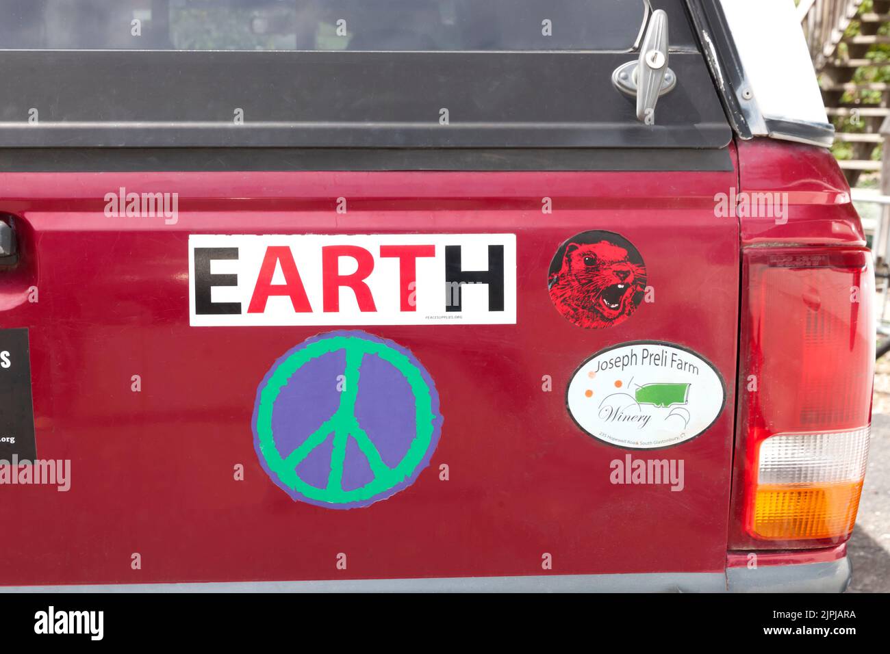 Car bumper with earth and peace sign bumper stickers. Stock Photo