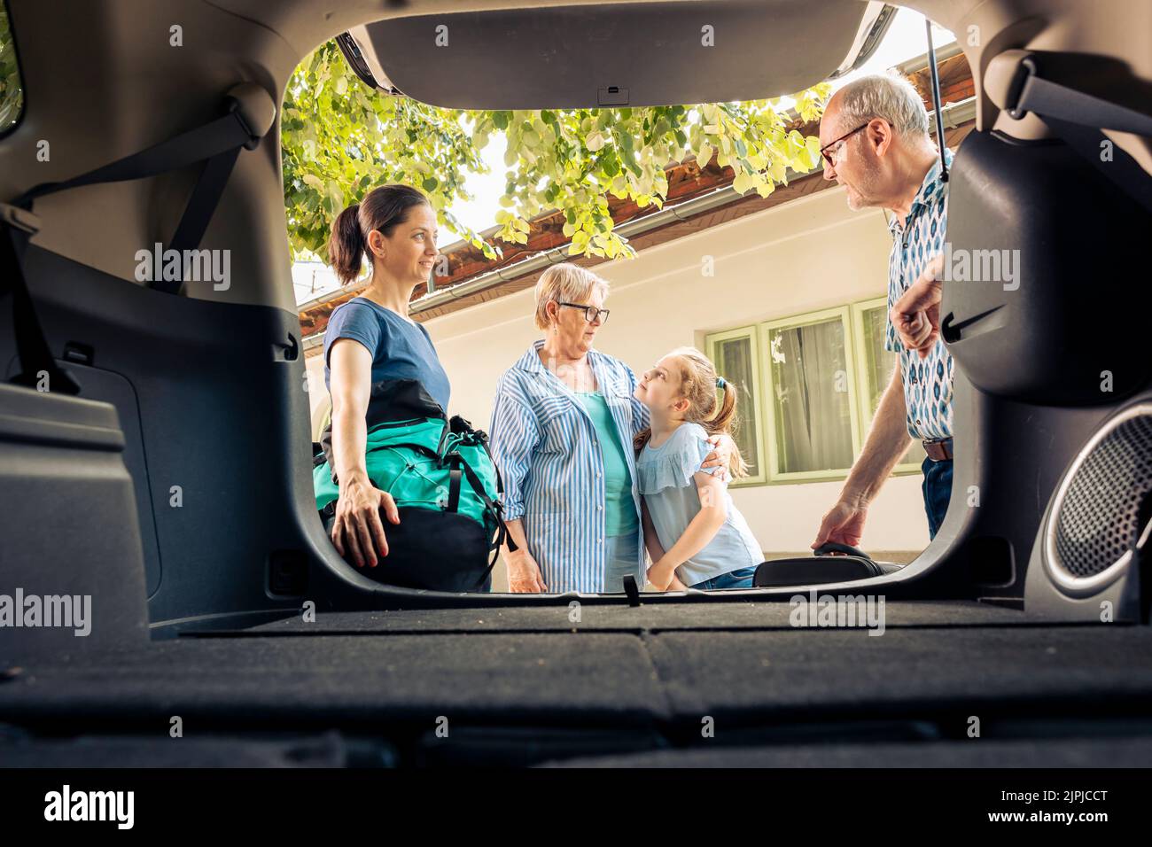 European family going on summer holiday with luggage and bags, loading