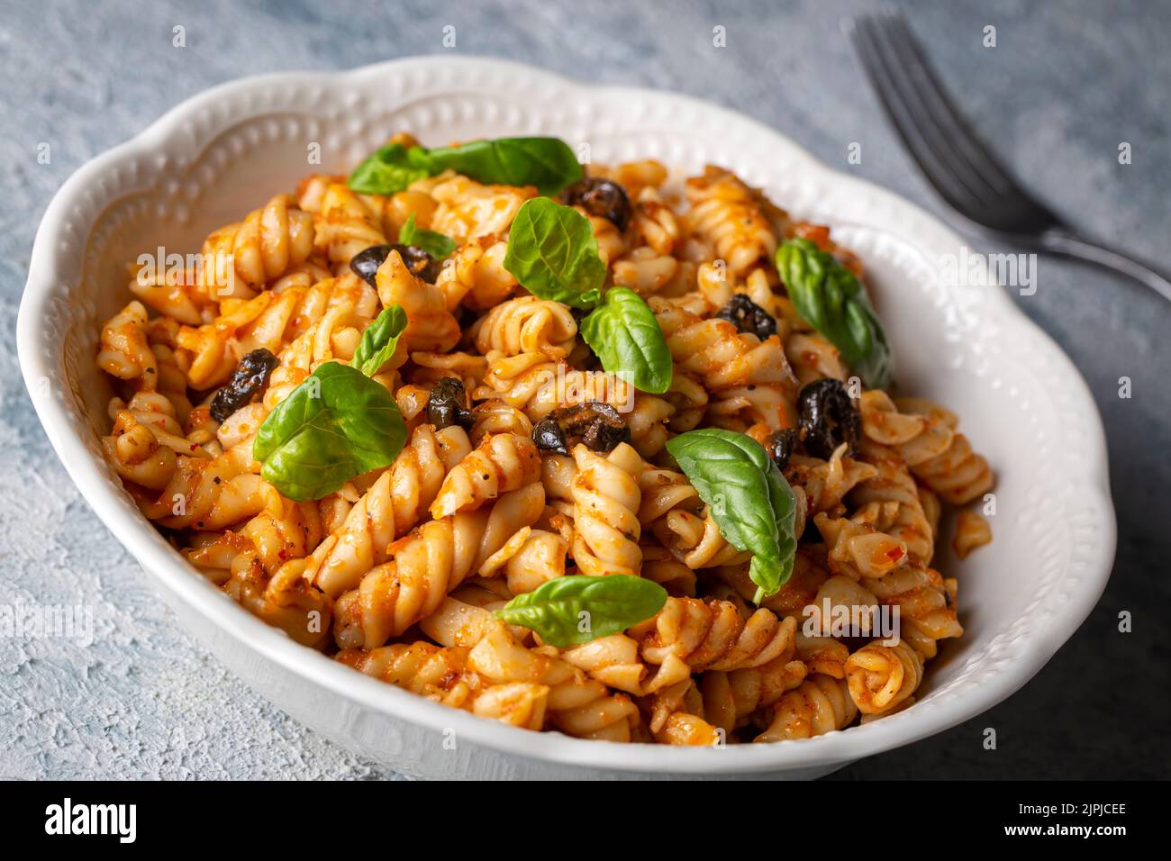Basil leaves on pasta with arabiata sauce Stock Photo Alamy