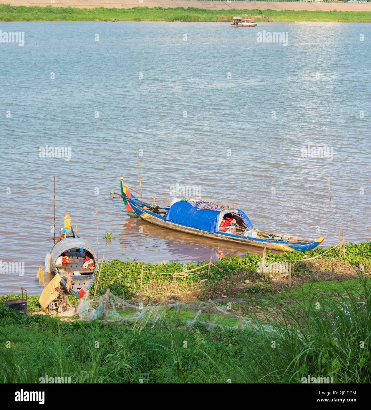 Traditional houseboats on the Mekong river. People who live on the riverboat. The boats are being used both as fishing and as a home Stock Photo