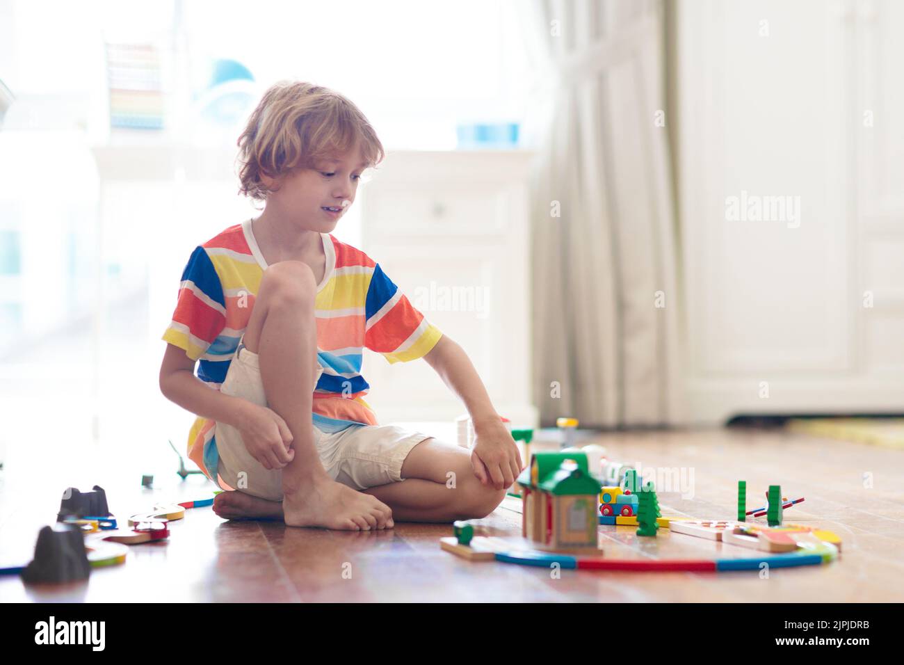 Kids play with wooden railway. Child with toy train. Educational toys