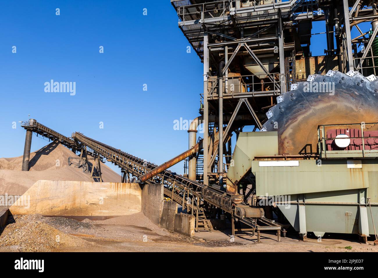 Close-up detail part of heavy metal construction of open pit gravel plant sand quarry big rusty rotor machine material excavating and crushing Stock Photo