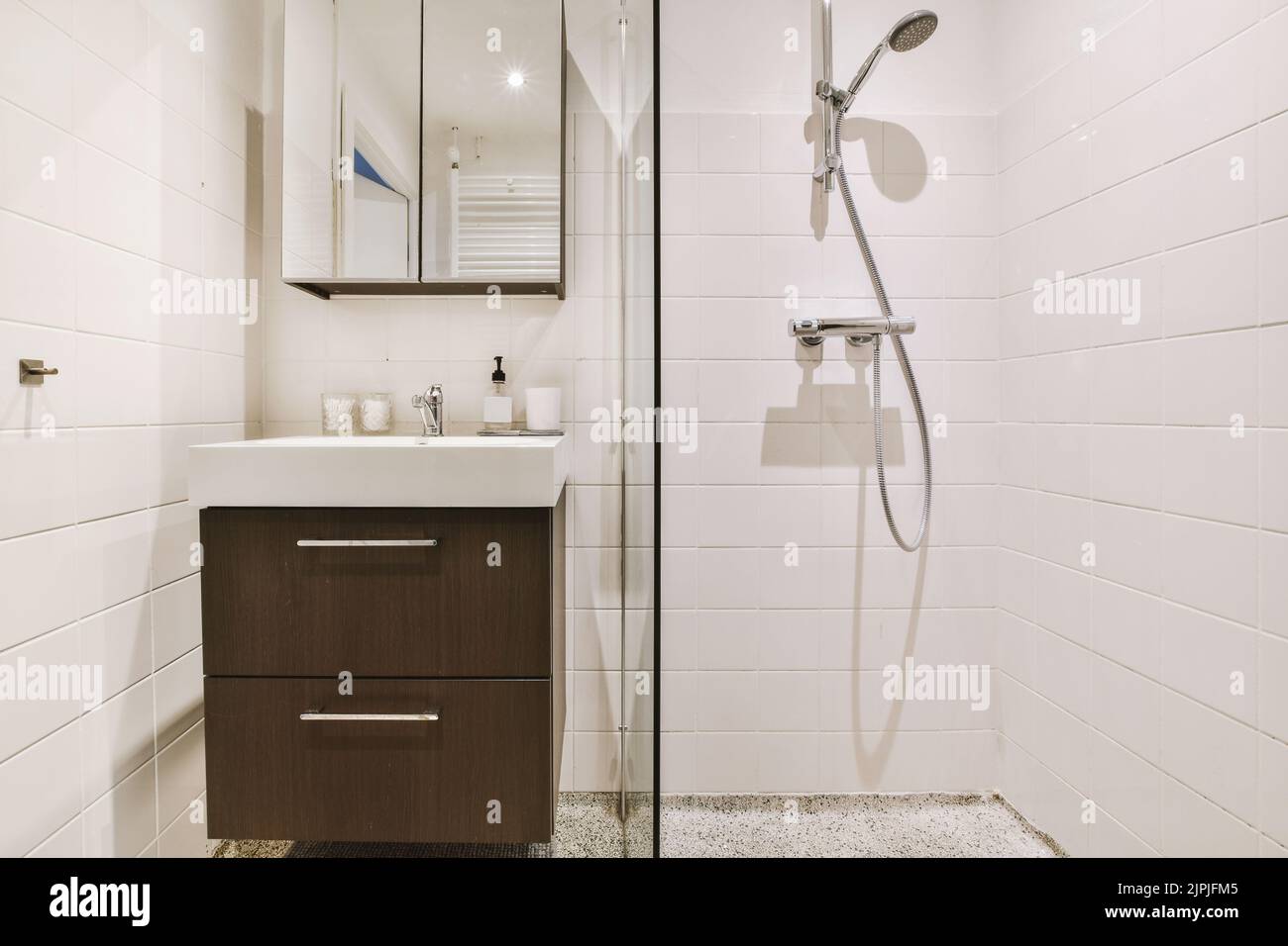 Sinks with mirrors and shower box with glass door in modern bathroom ...