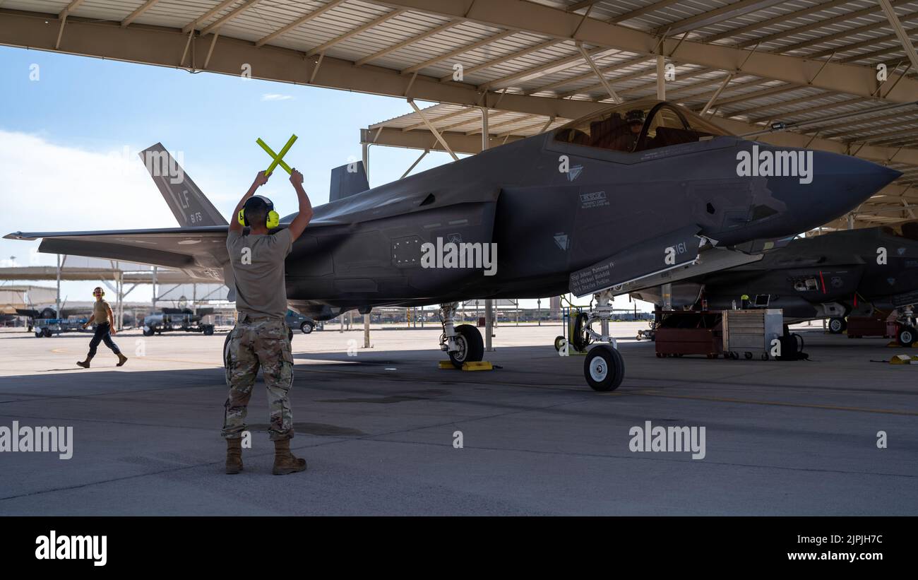 U.S. Air Force Airman 1st Class Elie Madrid, 61st Aircraft Maintenance Unit F-35 Lightning II crew chief, halts an F-35A, August 8, 2022, at Luke Air Force Base, Arizona. Crew chiefs are a vital part of the maintenance force that ensure aircraft are airworthy and mission-ready. (U.S. Air Force photo by Airman Mason Hargrove) Stock Photo