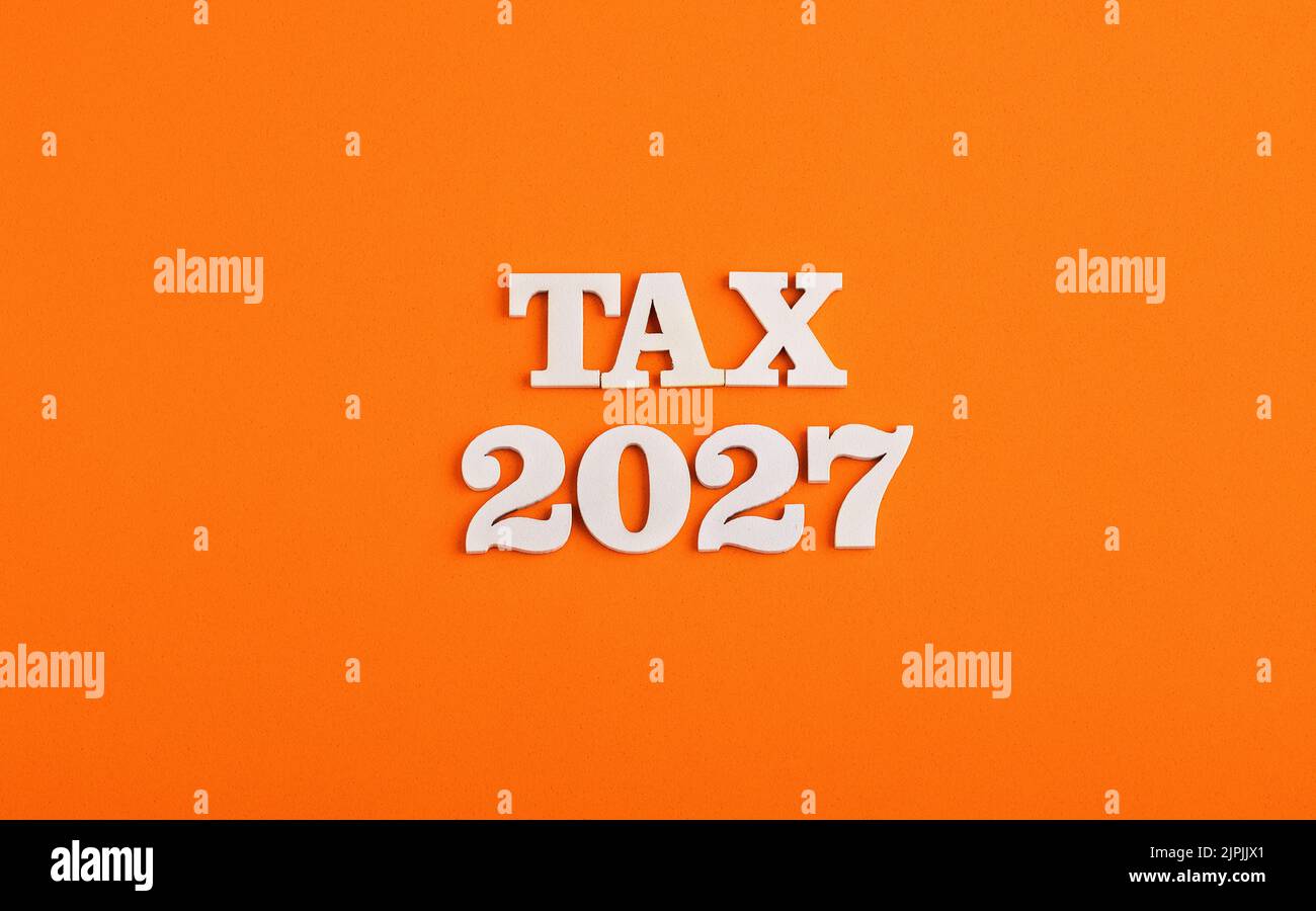 Taxes for the year 2027 Concept. White numbers on orange background Stock Photo Alamy