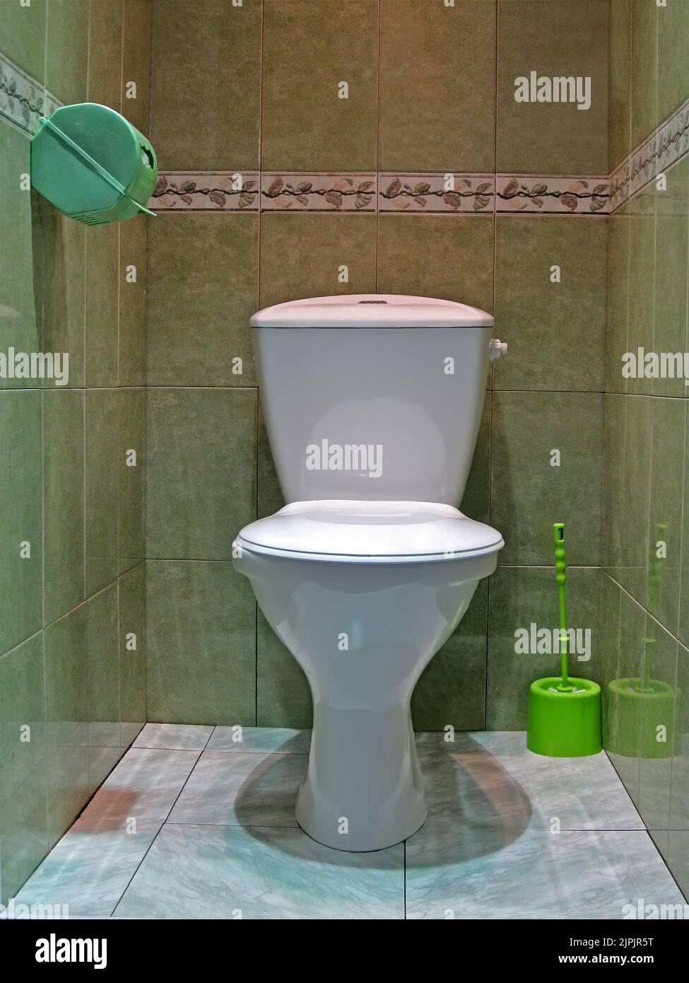 white water closet aka lavatory room, modern restroom with white ceramics toilet and green whisk on marble floor, everyday sanitary, daily hygiene, hy Stock Photo