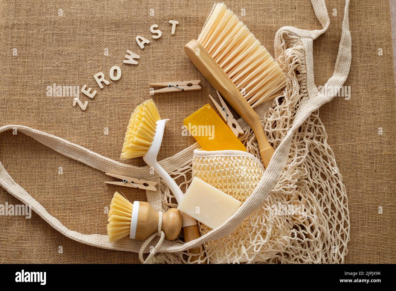 Mesh market bag eco-friendly accessories ecological brushes for kitchen , wooden clothespins ,dish brush, natural cleaning products on burlap Stock Photo