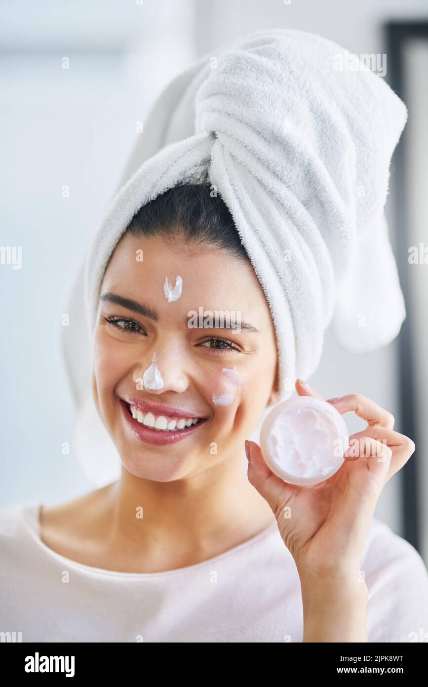 This lotion always works beautifully on my skin. Portrait of a beautiful young woman applying