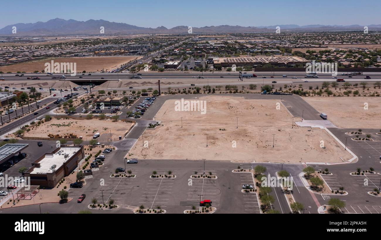 Afternoon aerial view of new shopping mall sprawl and empty lots of downtown Goodyear, Arizona, USA. Stock Photo