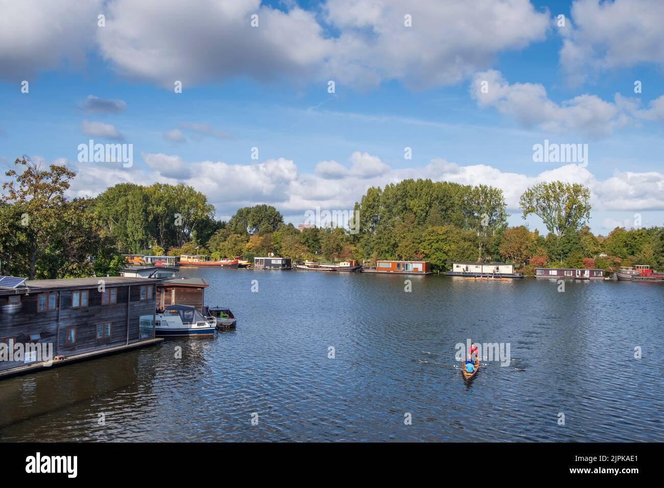 Crewing and Houseboats Amstel River in early Autumn, Amsterdam, Netherlands Stock Photo