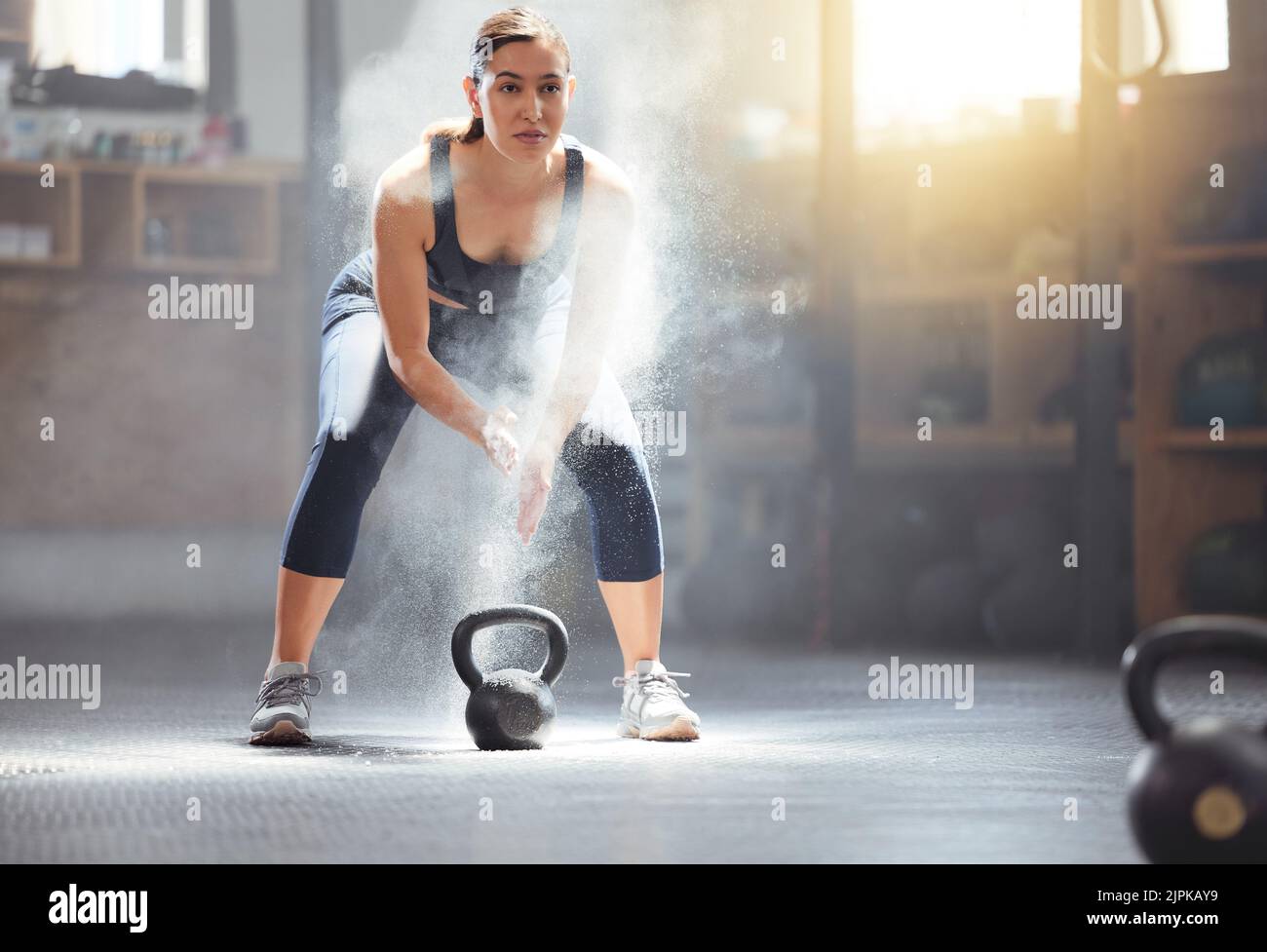 Fitness kettlebell and gym woman with chalk on hands during weightlifting workout, exercise or training. Athletic, active and strong girl exercising Stock Photo
