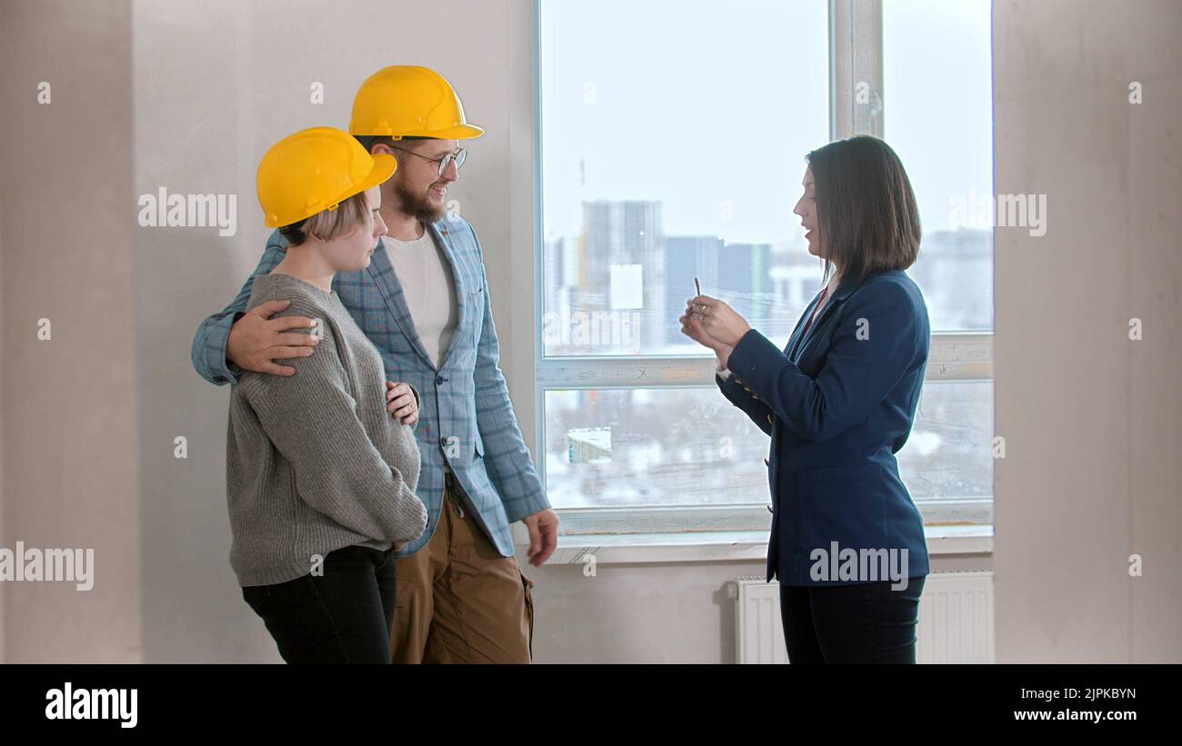 A real estate agent showing keys to apartment to a young family Stock Photo