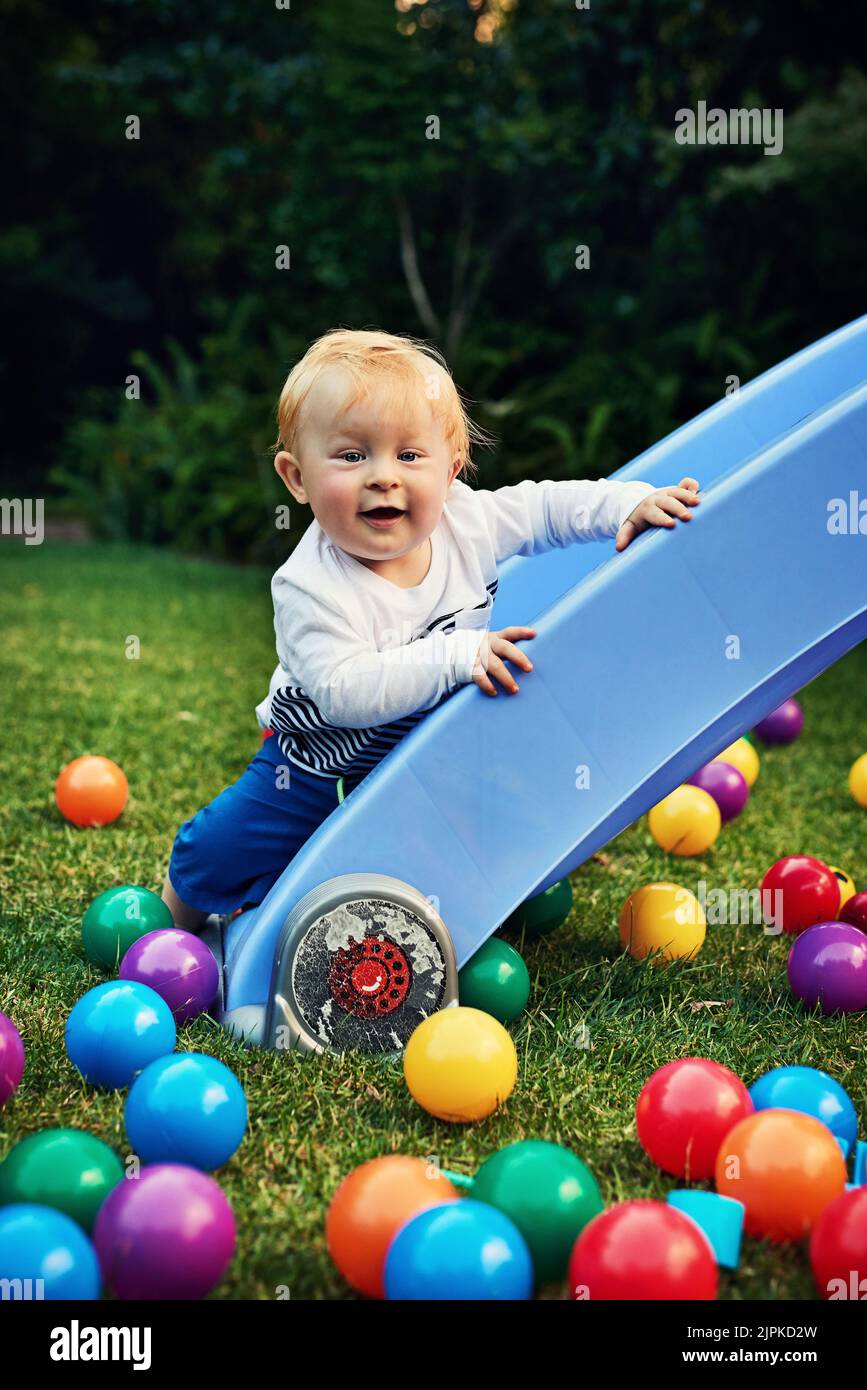 What goes up must come down. an adorable little boy playing in the backyard. Stock Photo