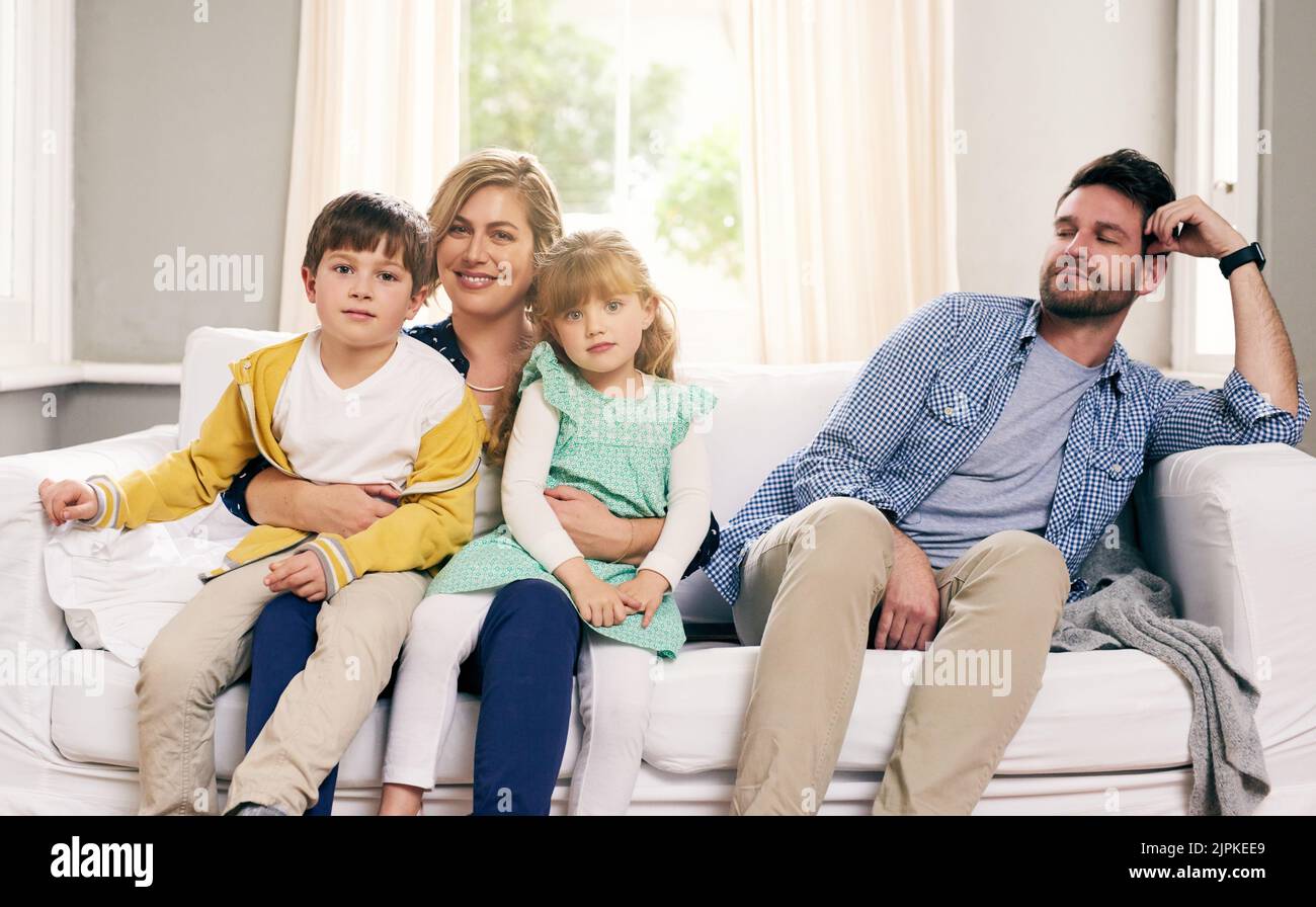 Feeling left out in my own family. a mother and children while the father stares at them with disdain at home. Stock Photo