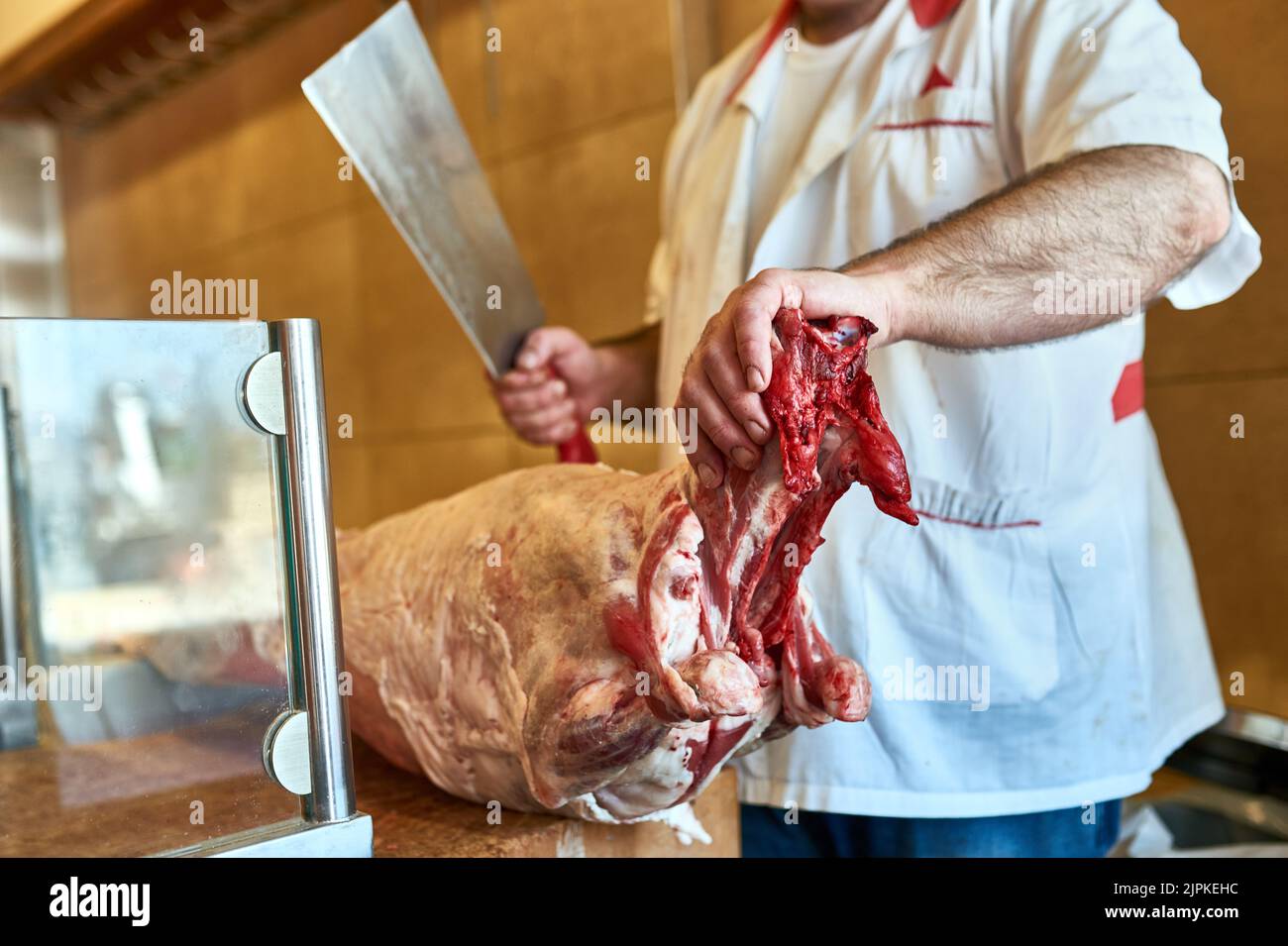 This will be chopped to perfection. a butcher at his store. Stock Photo