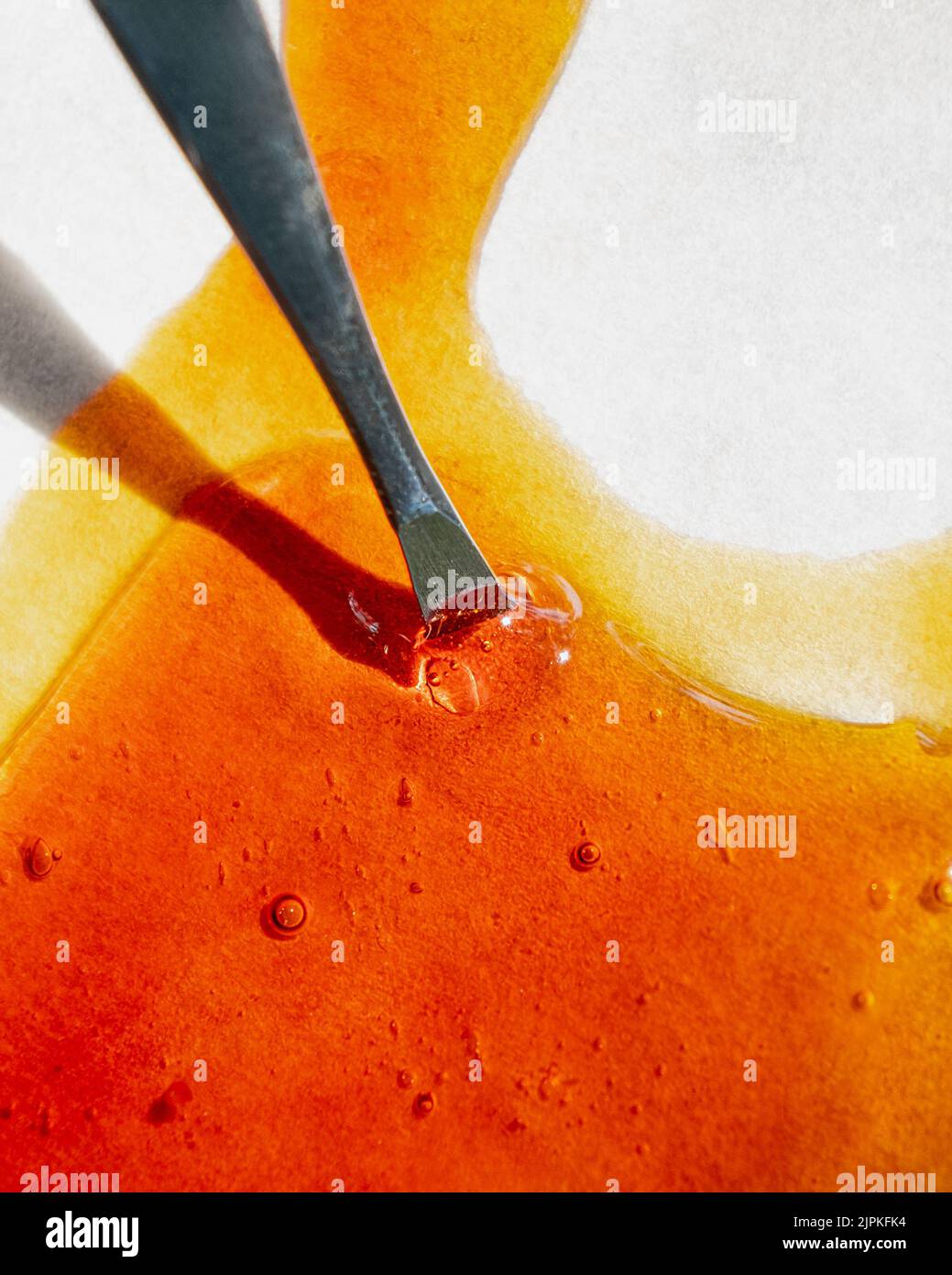 cannabis golden extract oil, metal stick and wax high thc Stock Photo