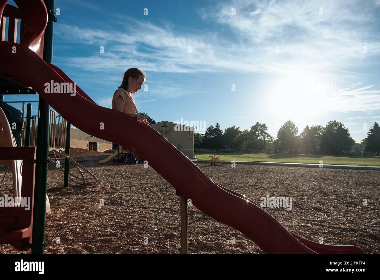 Young girl going down a slide on a playground Stock Photo Alamy